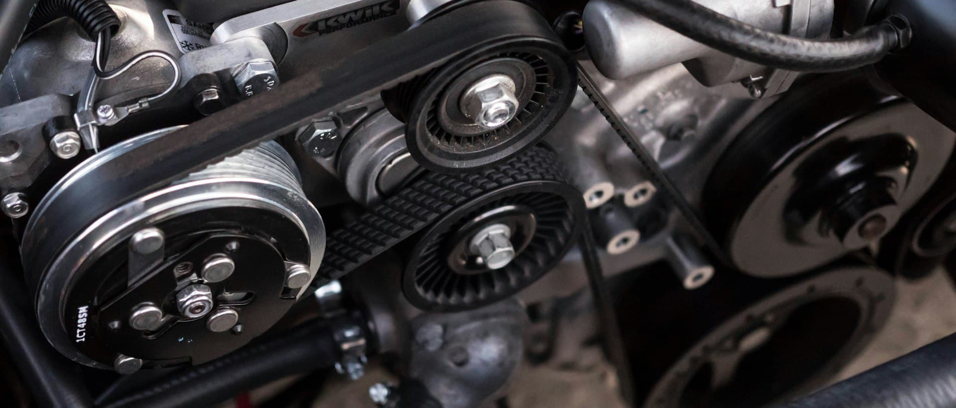 Close-up of a car engine belt and pulleys